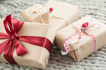 Gift boxes with ribbons on a handmade knitted cozy background. Christmas and New year concept. Valentine's Day presents. Happy Birthday. 