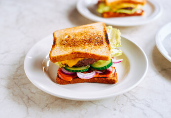 Homemade grilled sandwich with vegetables, sauce, cheese and beef cutlet