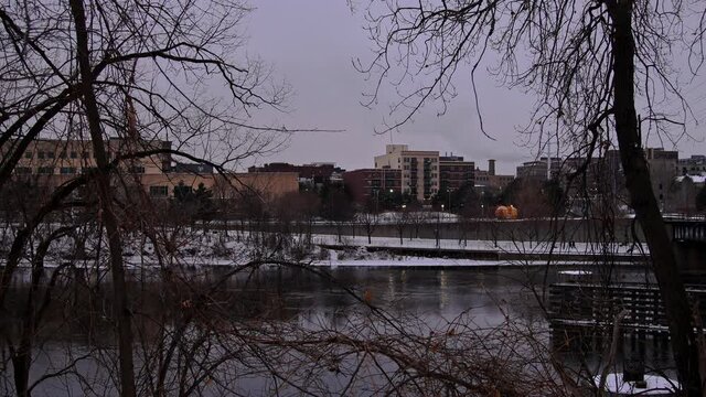 people walking dog running exercise in the snow cold winter by the river on a cloudy afternoon in minneapolis minnesota midwest usa 4k