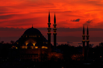 Silhouette of Süleymaniye Mosque on a background of evening red sky. Close-up. Sea of Marmara can...