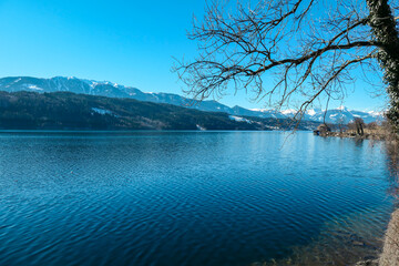 A panoramic view on the Millstaetter lake in Austria. The lake is surrounded by high Alps. Calm...
