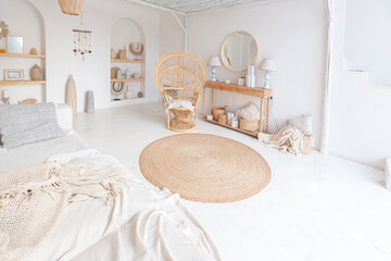 Cozy interior of a bright Balinese-style apartment with white walls, bamboo chair, big white sofa and decorations © 4595886