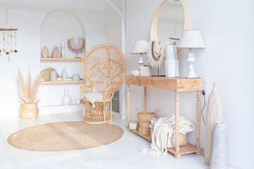 Cozy interior of a bright Balinese-style apartment with white walls, bamboo chair, big white sofa and decorations