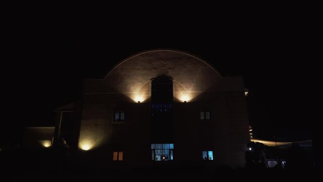 Night illumination of the building, colorful lights blinking in the windows, disco on the ground floor