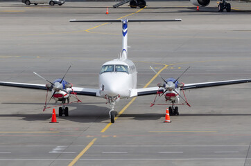 Small private jet turboprop parked, front view.
