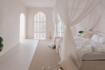 Cozy interior of a bright Balinese-style apartment with white walls, bamboo furniture. bed room with night lights, bed with balanchin and large windows © 4595886
