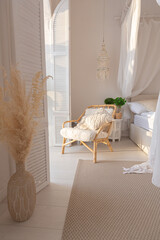 Cozy interior of a bright Balinese-style apartment with white walls, bamboo furniture. bed room...