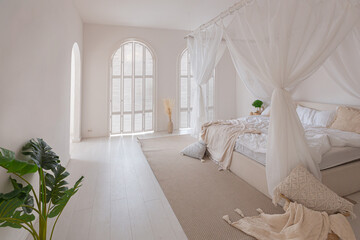 Cozy interior of a bright Balinese-style apartment with white walls, bamboo furniture. bed room with night lights, bed with balanchin and large windows © 4595886