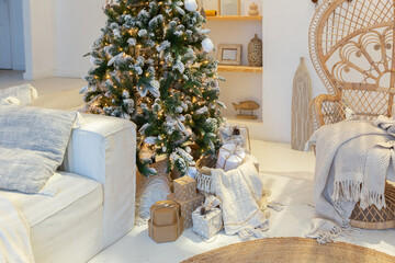 Cozy interior of a bright Balinese-style apartment with completely white walls, wicker furniture. sitting room full of day light decorated with Christmas tree