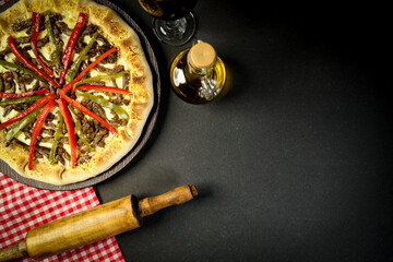 Pizza - tradicional brasileira, vegetais, ingredientes em um fundo escuro de madeira envelhecida....