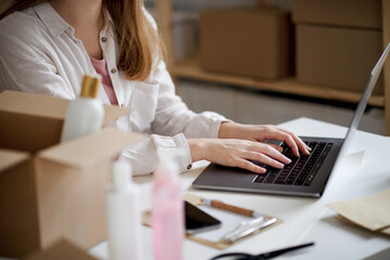 Unrecognizable woman dropshipper with laptop working at home, coronavirus concept.