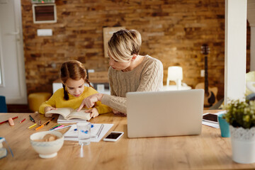 Working mother homeschooling her small daughter.