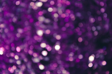 Abstract background with glowing blurred color circles. Bokeh in violet colors. Glitter vintage lights background. Defocused. Festive Valentine's Day and Christmas background in lilac lights