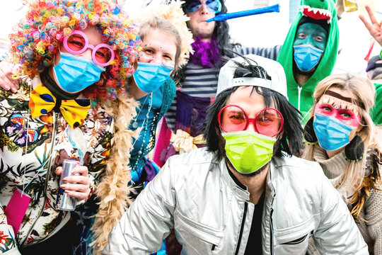 Karneval Party. Gruppe freuliche junger Leute feiern Fasching mit Atemschutz-masken. Corona Konzept.