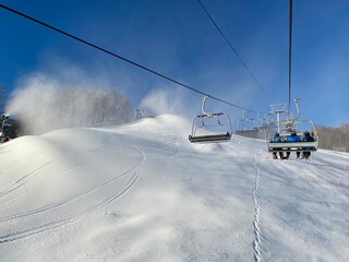 Obraz premium Chairlift going up during snowmaking in progress at Stowe ski resort, VT USA