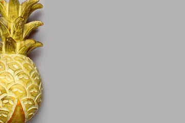 Trendfarben des Jahres 2021. Leuchtendes und ultimatives Grau. Hölzerne gelbe Ananas auf grauem Hintergrund, flach, Draufsicht, Kopienraum. Kreatives Modell mit bemalter Ananas. Sommerkonzept © olgaarkhipenko