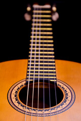 Obraz premium Close-up of an acoustic guitar lies on its side. Perspective frame with highly blurred background