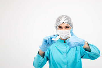 Fototapeta na wymiar Positive medical worker in protective clothing,gloves and mask holding a syringe and showing the thumb up sign.Medicine and healthcare concept.Coronavirus vaccination concept.