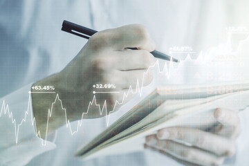 Multi exposure of abstract financial graph with hand writing in notebook on background, financial...