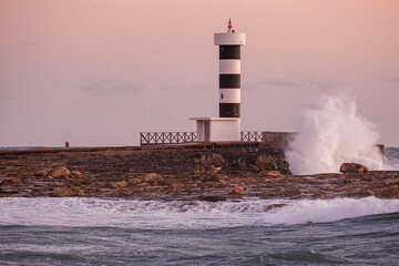 Obraz premium strong waves on the Puntassa lighthouse in Colònia de Sant Jordi, ses Salines, Mallorca, Balearic Islands, Spain