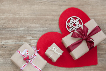 Love concept. Vlentine's Day. Festive boxes with  satin ribbons, gifts and red big heart on wooden background.
