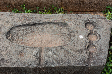 Hampi, Karnataka, India - November 5, 2013: Ancient Aqueduct. Closeup of 1 gray border stone with...