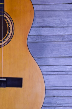 Part of acoustic guitar close up on painted wooden background
