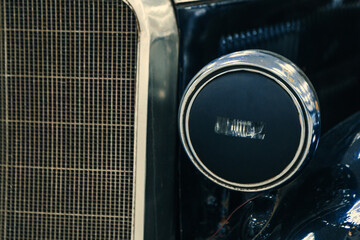front halogen headlights and radiator of black retro car on display