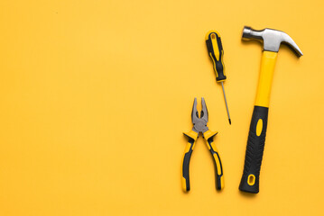 Construction tools on the yellow flat lay background with copy space.