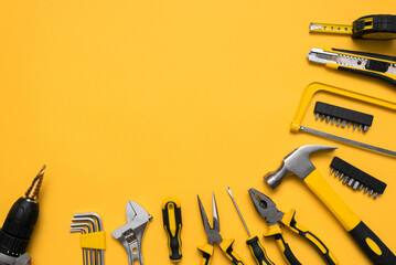 Construction tools on the yellow flat lay background with copy space.