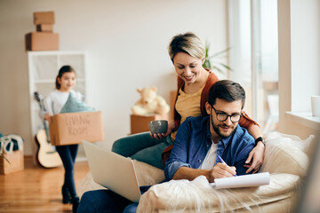 Happy parents with daughter relocating into a new apartment.