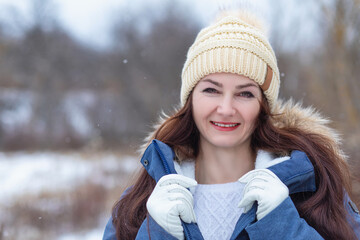 Woman smiling in winter hat and jacket .