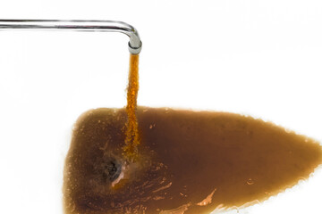 Rusty or dirty water flowing from a tap into a white bathtub or sink