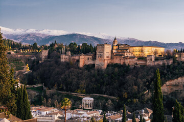 Alhambra muslim palace in Granada at sunset with buildings below from San Nicolas lookout