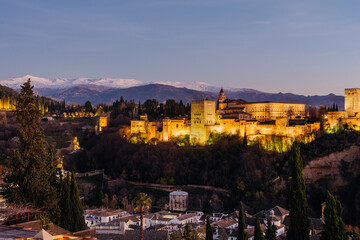 Alhambra muslim palace in Granada at night with buildings below from San Nicolas lookout
