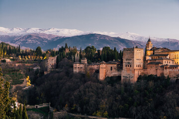 Alhambra palace in Granada at sunset with snow in the mountains in the back from San Nicolas lookout