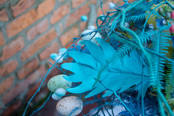Stylish easter bouquet in blue tones over brick wall background, selective focus, copy space