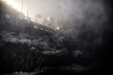 metal construction in snowfall. Abstract background of glossy iced surface of ribbed metal wall and covered by snow