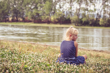 cute child by the river relaxing and watching the water in the river
