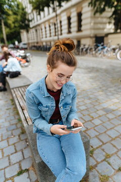 Young woman relaxing in town with her mobile