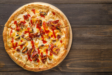 Fresh pizza with tomato sauce, black olives, mozzarella cheese, ham on wooden table closeup. Space for text or copy space. Pizza menu. Restaurant menu advertise