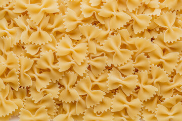 Traditional Italian farfalle pasta. Italian Cuisine. Bow tie noodles. Uncooked dried farfalle. Butterfly. Top view.