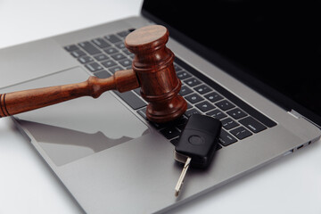 Judge gavel and car keys on laptop computer keyboard. Symbol of law, justice and online car auction