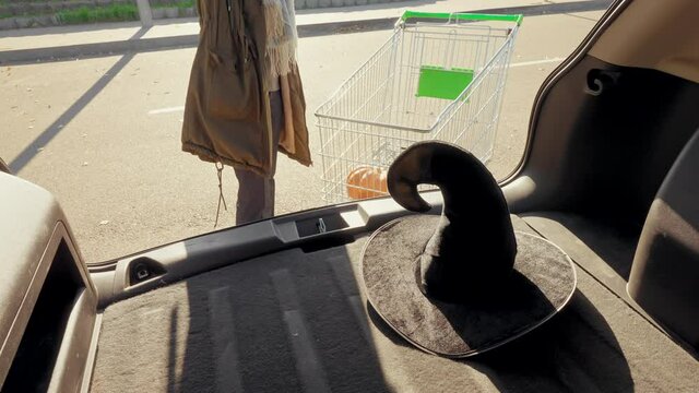customer at parking area near store eve of All Saints' Day shopping before halloween slow motion
