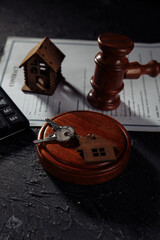 Judge gavel and house keys on gray table. Real estate law, house arrest concept. Vertical image.