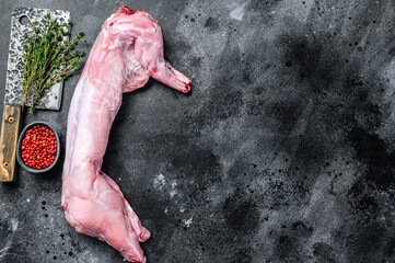 Raw hare meat with spices for cooking. Black background. Top view. Copy space
