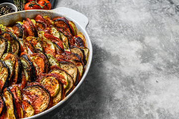 Traditional homemade vegetable ratatouille baked in dish. Gray background. Top view. Copy space