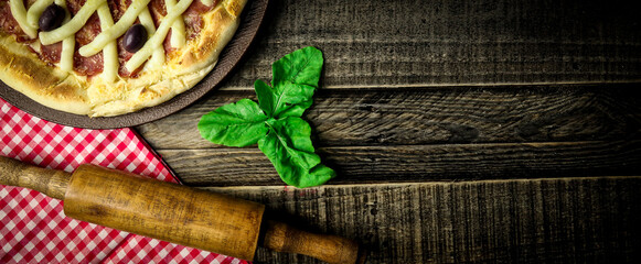 Fototapeta na wymiar Pizza - tradicional brasileira, vegetais, ingredientes em um fundo escuro de madeira envelhecida. Espaço para texto.