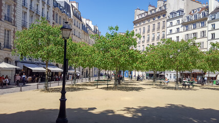 Place Dauphine in Paris with houses, restaurants, cafes. The tranquil square has a lot of benches...