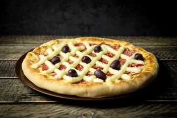 Pizza - tradicional brasileira, vegetais, ingredientes em um fundo escuro de madeira envelhecida. Espaço para texto.